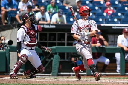 Jun 17, 2022; Omaha, NE, USA; Oklahoma Sooners second baseman Jackson Nicklaus (15) hits a grand slam home run against the Texas A&M Aggies in the fourth inning at Charles Schwab Field. Mandatory Credit: Steven Branscombe-USA TODAY Sports