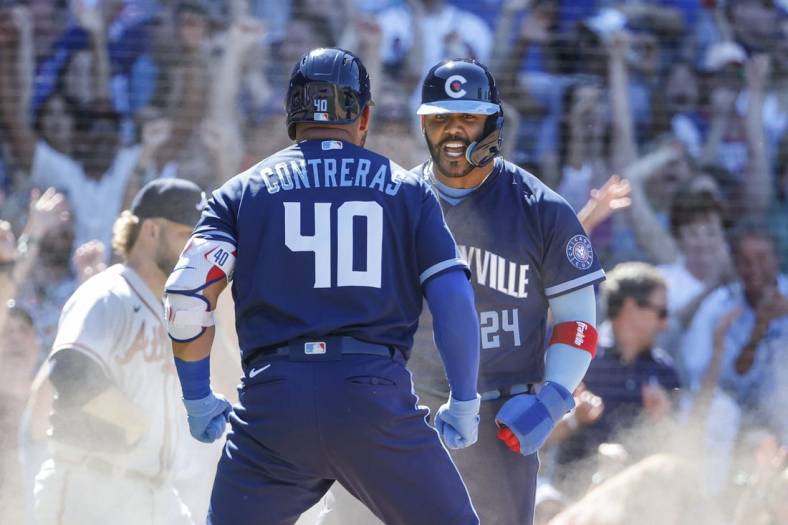 Jun 17, 2022; Chicago, Illinois, USA; Chicago Cubs second baseman Jonathan Villar (24) celebrates with designated hitter Willson Contreras (40) after scoring against the Atlanta Braves during the eight inning at Wrigley Field. Mandatory Credit: Kamil Krzaczynski-USA TODAY Sports
