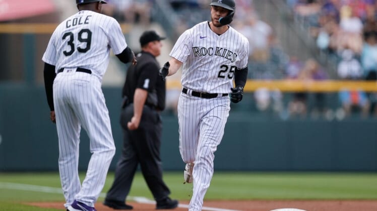 Jun 17, 2022; Denver, Colorado, USA; Colorado Rockies first baseman C.J. Cron (25) reacts with third base coach Stu Cole (39) after hitting a two run home run in the first inning against the San Diego Padres at Coors Field. Mandatory Credit: Isaiah J. Downing-USA TODAY Sports