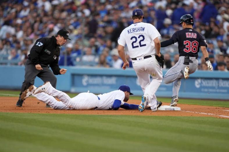 Jun 17, 2022; Los Angeles, California, USA; Cleveland Guardians left fielder Steven Kwan (38) beats a tag by Los Angeles Dodgers first baseman Freddie Freeman (5) on an infield single in the third inning as starting pitcher Clayton Kershaw (22) and umpire DJ Reyburn (17) watch at Dodger Stadium. Mandatory Credit: Kirby Lee-USA TODAY Sports
