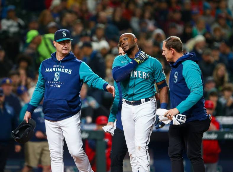Jun 17, 2022; Seattle, Washington, USA; Seattle Mariners left fielder Justin Upton (8) is walked off the field by manager Scott Servais after being hit by a pitch against the Los Angeles Angels during the fifth inning at T-Mobile Park. Upton would leave the game and be replaced by left fielder Dylan Moore. Mandatory Credit: Lindsey Wasson-USA TODAY Sports