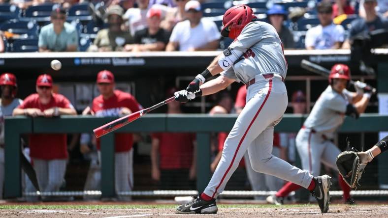 Jun 18, 2022; Omaha, NE, USA;  Arkansas Razorbacks right fielder Chris Lanzilli (18) launches a three-run home run in the fifth inning against the Stanford Cardinal at Charles Schwab Field. Mandatory Credit: Steven Branscombe-USA TODAY Sports