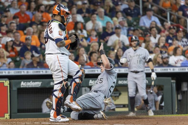 Jun 18, 2022; Houston, Texas, USA; Chicago White Sox designated hitter Andrew Vaughn (25) slides home safely against Houston Astros catcher Martin Maldonado (15) in the fourth inning at Minute Maid Park. Mandatory Credit: Thomas Shea-USA TODAY Sports