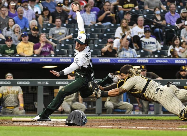 Jun 18, 2022; Denver, Colorado, USA; Colorado Rockies third baseman Ryan McMahon (24) is tagged out at home plate by San Diego Padres catcher Jorge Alfaro (38) in the fourth inning at Coors Field. Mandatory Credit: John Leyba-USA TODAY Sports