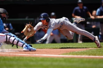 Jun 19, 2022; Baltimore, Maryland, USA; Tampa Bay Rays right fielder Brett Phillips (35) dives before being tagged out by Baltimore Orioles catcher Adley Rutschman (35) during the second inning at Oriole Park at Camden Yards. Mandatory Credit: Scott Taetsch-USA TODAY Sports