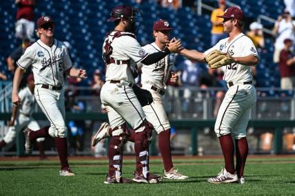 Jun 19, 2022; Omaha, NE, USA;  Texas A&M Aggies pitcher Brad Rudis (32) and catcher Troy Claunch (12) celebrate the win against the Texas Longhorns at Charles Schwab Field. Mandatory Credit: Steven Branscombe-USA TODAY Sports