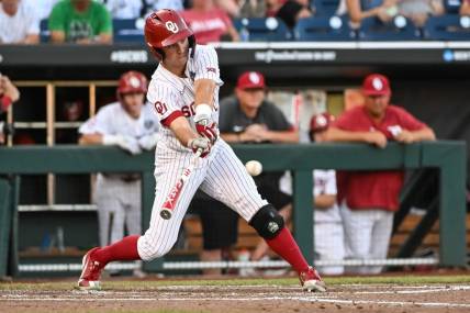 Jun 19, 2022; Omaha, NE, USA;  Oklahoma Sooners center fielder Tanner Tredaway (10) singles in a run against the Notre Dame Fighting Irish in the third inning at Charles Schwab Field. Mandatory Credit: Steven Branscombe-USA TODAY Sports