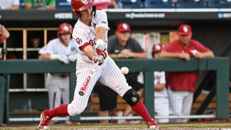 Jun 19, 2022; Omaha, NE, USA;  Oklahoma Sooners center fielder Tanner Tredaway (10) singles in a run against the Notre Dame Fighting Irish in the third inning at Charles Schwab Field. Mandatory Credit: Steven Branscombe-USA TODAY Sports