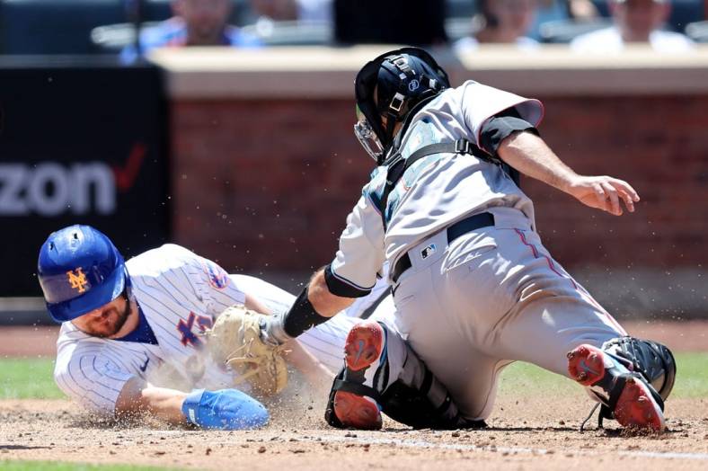 Jun 20, 2022; New York City, New York, USA; New York Mets designated hitter J.D. Davis (28) scores on a sacrifice fly by third baseman Eduardo Escobar (not pictured) ahead of the tag by Miami Marlins catcher Jacob Stallings (58) during the fourth inning at Citi Field. Mandatory Credit: Brad Penner-USA TODAY Sports