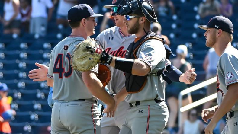 Jun 20, 2022; Omaha, NE, USA;  Auburn Tigers pitcher Blake Burkhalter (40) and catcher Nate LaRue (28) meet after the win against the Stanford Cardinal at Charles Schwab Field. Mandatory Credit: Steven Branscombe-USA TODAY Sports