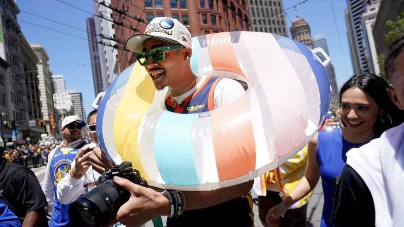 Jun 20, 2022; San Francisco, CA, USA; Golden State Warriors guard Jordan Poole wears a swim tube during the Warriors championship parade in downtown San Francisco. Mandatory Credit: Cary Edmondson-USA TODAY Sports