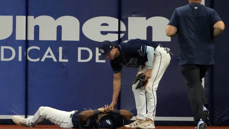 Jun 20, 2022; St. Petersburg, Florida, USA;  Injured Tampa Bay Rays right fielder Manuel Margot (13) is checked on by  Brett Phillips (35) as a trainer runs to assist at Tropicana Field. Mandatory Credit: Dave Nelson-USA TODAY Sports