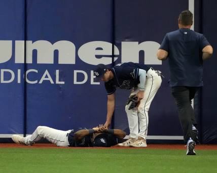 Jun 20, 2022; St. Petersburg, Florida, USA;  Injured Tampa Bay Rays right fielder Manuel Margot (13) is checked on by  Brett Phillips (35) as a trainer runs to assist at Tropicana Field. Mandatory Credit: Dave Nelson-USA TODAY Sports