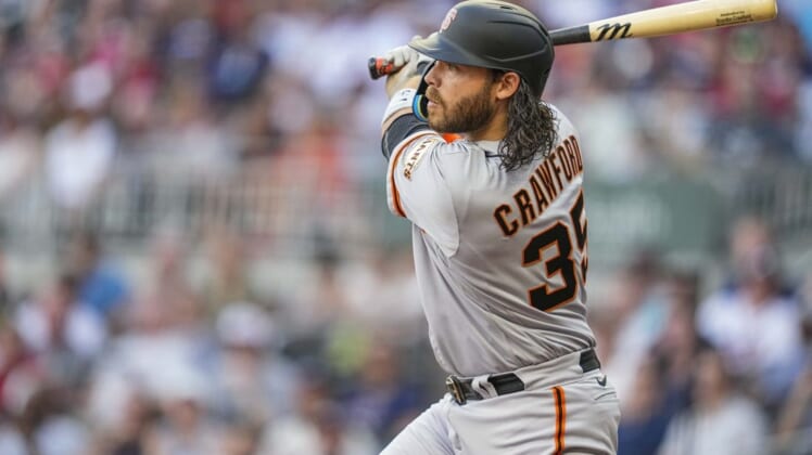 Jun 21, 2022; Cumberland, Georgia, USA; San Francisco Giants shortstop Brandon Crawford (35) hits a sacrifice fly ball to drive in a run against the Atlanta Braves during the second inning at Truist Park. Mandatory Credit: Dale Zanine-USA TODAY Sports