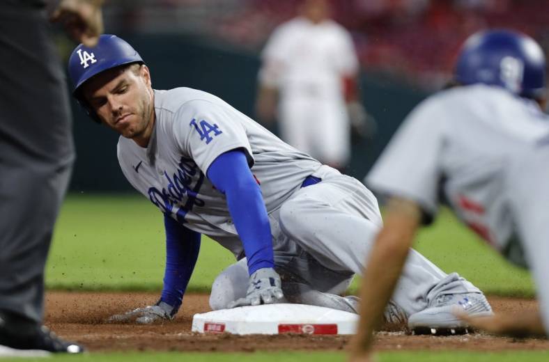 Jun 21, 2022; Cincinnati, Ohio, USA; Los Angeles Dodgers first baseman Freddie Freeman (5) slides safely into third base after hitting a three-run triple against the Cincinnati Reds during the eighth inning at Great American Ball Park. Mandatory Credit: David Kohl-USA TODAY Sports