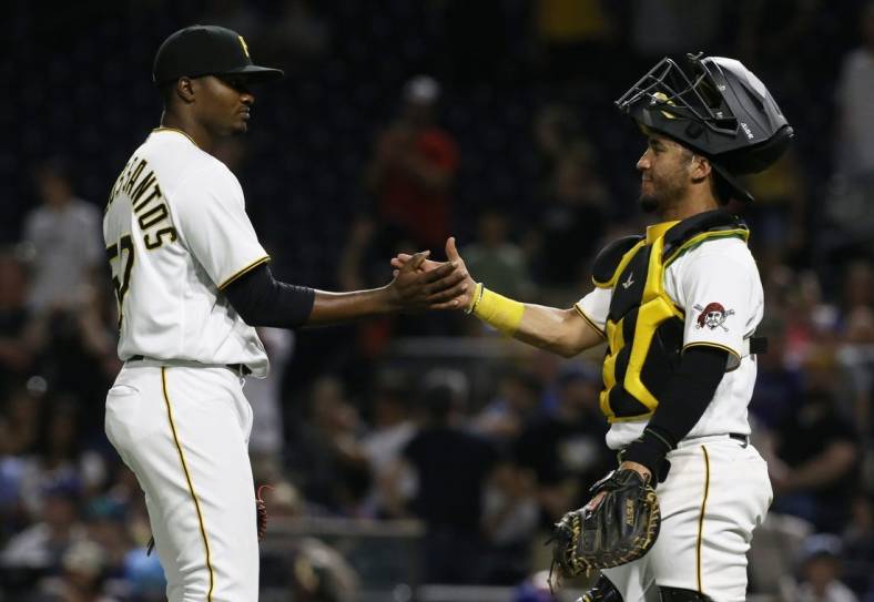 Jun 21, 2022; Pittsburgh, Pennsylvania, USA;  Pittsburgh Pirates relief pitcher Yerry De Los Santos (57) and catcher Michael Perez (5) shake hands after defeating the Chicago Cubs at PNC Park. Pittsburgh won 7-1. Mandatory Credit: Charles LeClaire-USA TODAY Sports