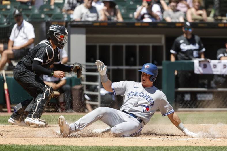 Jun 22, 2022; Chicago, Illinois, USA; Toronto Blue Jays third baseman Matt Chapman (26) slides safely into home as Chicago White Sox catcher Reese McGuire (21) is unable to tag him out during the fourth inning at Guaranteed Rate Field. Mandatory Credit: Kamil Krzaczynski-USA TODAY Sports