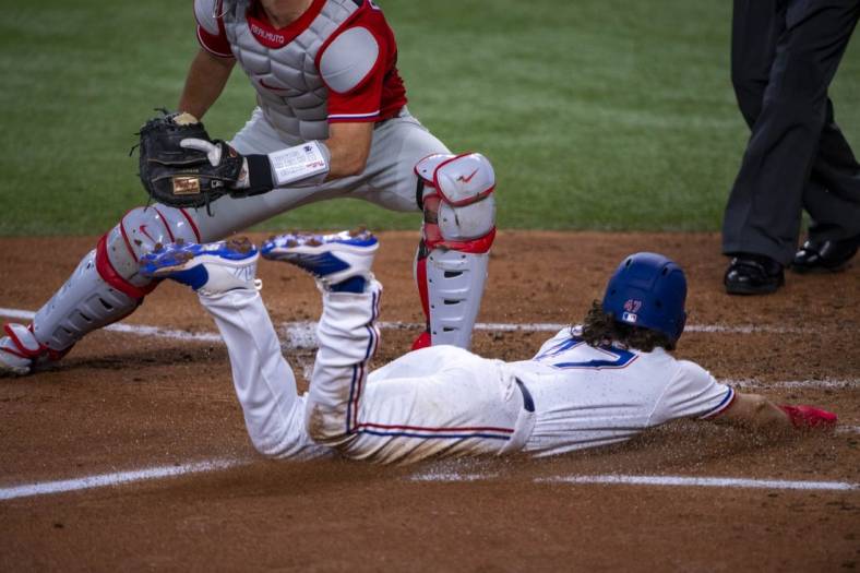 Jun 22, 2022; Arlington, Texas, USA; Texas Rangers left fielder Josh Smith (47) slides into home plate and scores against the Philadelphia Phillies during the second inning at Globe Life Field. Mandatory Credit: Jerome Miron-USA TODAY Sports
