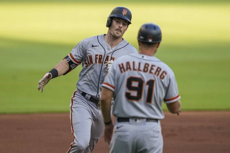 Jun 22, 2022; Cumberland, Georgia, USA; San Francisco Giants Mike Yastrzemski (5) reacts with third base coach Mark Hallberg (91) after hitting a home run against the Atlanta Braves during the first inning at Truist Park. Mandatory Credit: Dale Zanine-USA TODAY Sports