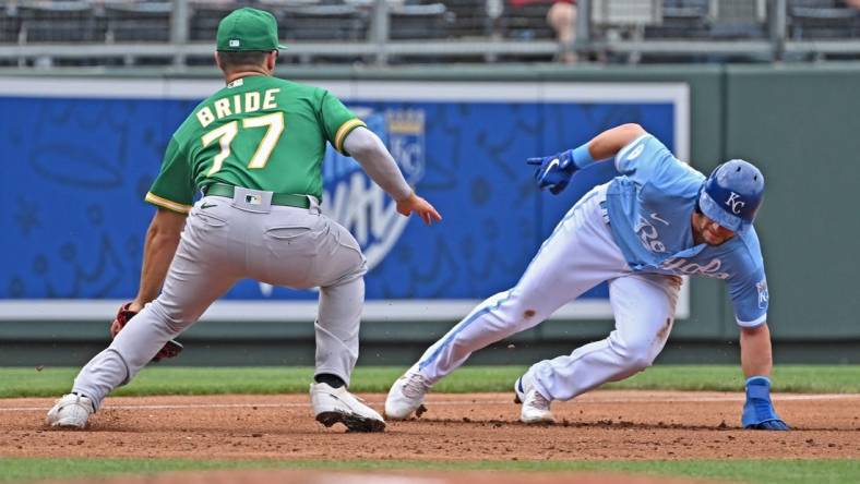 Jun 25, 2022; Kansas City, Missouri, USA;  Kansas City Royals left fielder Andrew Benintendi (16) avoids the tag from Oakland Athletics third baseman Jonah Bride (77) at third base during the first inning at Kauffman Stadium. Mandatory Credit: Peter Aiken-USA TODAY Sports