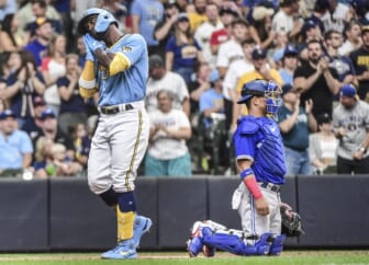 Jun 25, 2022; Milwaukee, Wisconsin, USA; Milwaukee Brewers designated hitter Andrew McCutchen (24) reacts after hitting a 2-run homer in the second inning as Toronto Blue Jays catcher Gabriel Moreno (55) looks on at American Family Field. Mandatory Credit: Benny Sieu-USA TODAY Sports