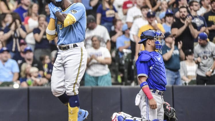 Jun 25, 2022; Milwaukee, Wisconsin, USA; Milwaukee Brewers designated hitter Andrew McCutchen (24) reacts after hitting a 2-run homer in the second inning as Toronto Blue Jays catcher Gabriel Moreno (55) looks on at American Family Field. Mandatory Credit: Benny Sieu-USA TODAY Sports