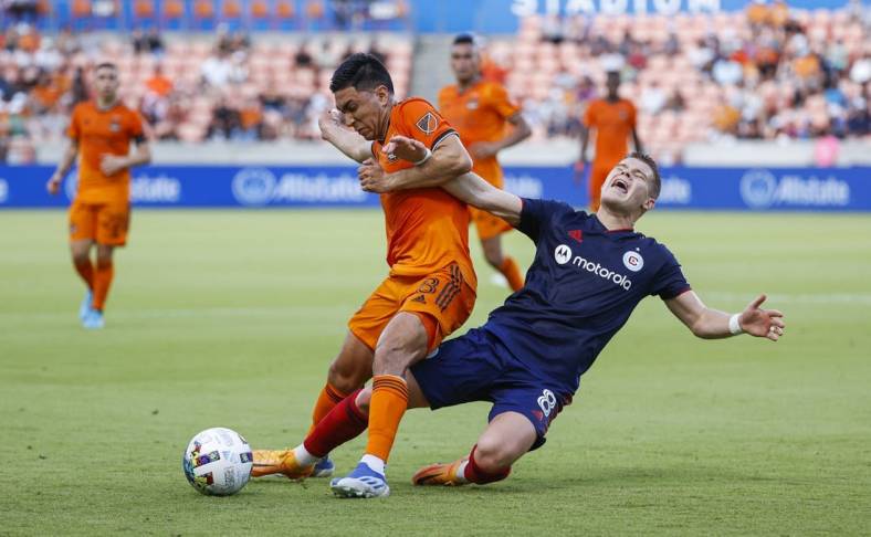 Jun 25, 2022; Houston, Texas, USA;  Houston Dynamo FC midfielder Memo Rodriguez (8) and Chicago Fire midfielder Chris Mueller (8) battle for the ball during the first half at PNC Stadium. Mandatory Credit: Troy Taormina-USA TODAY Sports