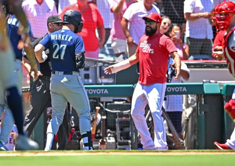 Jun 26, 2022; Anaheim, California, USA;  Seattle Mariners right fielder Jesse Winker (27) engages with Los Angeles Angels Anthony Rendon (6) during a benches clearing brawl in the second inning at Angel Stadium. Mandatory Credit: Jayne Kamin-Oncea-USA TODAY Sports