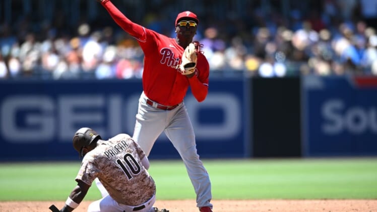 Jun 26, 2022; San Diego, California, USA; Philadelphia Phillies shortstop Didi Gregorius (top) throws to first base late after forcing out San Diego Padres left fielder Jurickson Profar (10) at second base during the third inning at Petco Park. Mandatory Credit: Orlando Ramirez-USA TODAY Sports