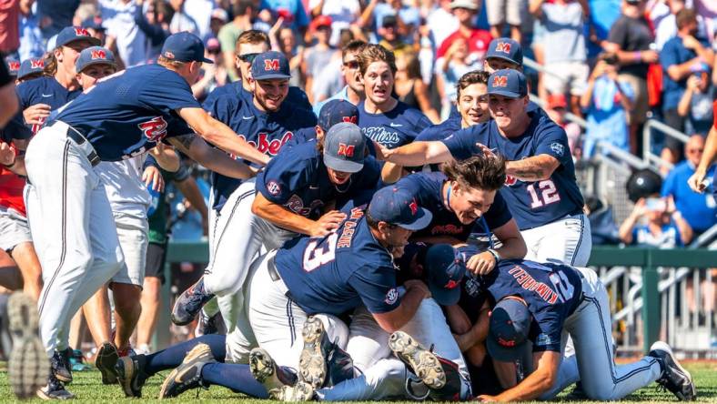 Jun 26, 2022; Omaha, NE, USA; Ole Miss Rebels players dogpile after defeating the Oklahoma Sooners at Charles Schwab Field. Mandatory Credit: Dylan Widger-USA TODAY Sports