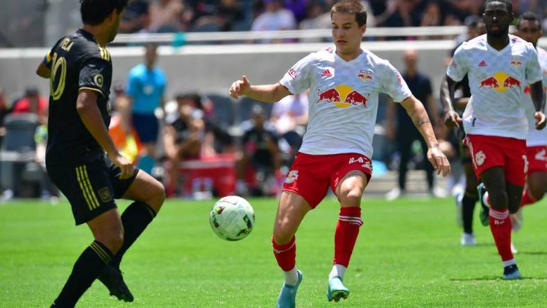 Jun 26, 2022; Los Angeles, California, USA; New York Red Bulls defender John Tolkin (47) plays for the ball against Los Angeles FC forward Carlos Vela (10) during the second half at Banc of California Stadium. Mandatory Credit: Gary A. Vasquez-USA TODAY Sports