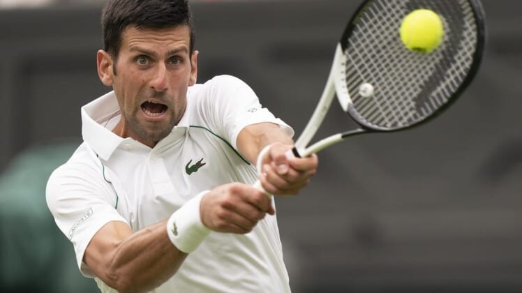 Jun 27, 2022; London, United Kingdom;  Novak Djokovic (SRB) returns a shot during his first round match against Soonwoo Kwon (KOR) on day one at All England Lawn Tennis and Croquet Club. Mandatory Credit: Susan Mullane-USA TODAY Sports