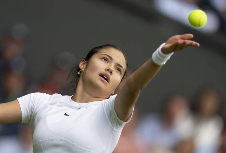 Jun 27, 2022; London, United Kingdom;  Emma Raducanu (GBR) tosses the ball to serve during her first round match against Alison Van Uytvanck (BEL) on day one at All England Lawn Tennis and Croquet Club. Mandatory Credit: Susan Mullane-USA TODAY Sports