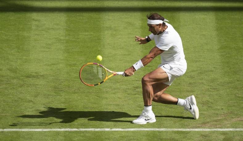 Jun 28, 2022; London, United Kingdom; Rafael Nadal (ESP) returns a shot during his first round match against Francisco Cerundolo (ARG) on day two at All England Lawn Tennis and Croquet Club. Mandatory Credit: Susan Mullane-USA TODAY Sports