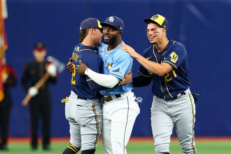 Jun 28, 2022; St. Petersburg, Florida, USA;  Tampa Bay Rays left fielder Randy Arozarena (56) is greeted by Milwaukee Brewers shortstop Willy Adames (27) and shortstop Luis Urias (2) before a game at Tropicana Field. Mandatory Credit: Nathan Ray Seebeck-USA TODAY Sports