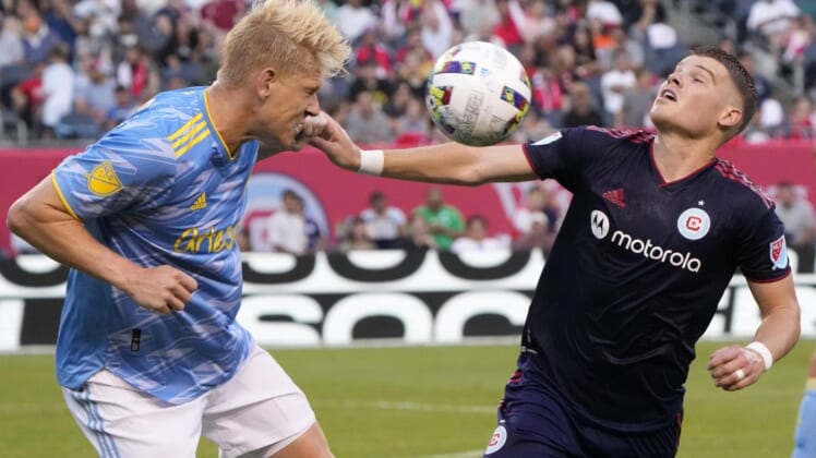 Jun 29, 2022; Chicago, Illinois, USA; Philadelphia Union defender Jakob Glesnes (5) heads the ball against Chicago Fire forward Chris Mueller (8) during the first half at Soldier Field. Mandatory Credit: Mike Dinovo-USA TODAY Sports