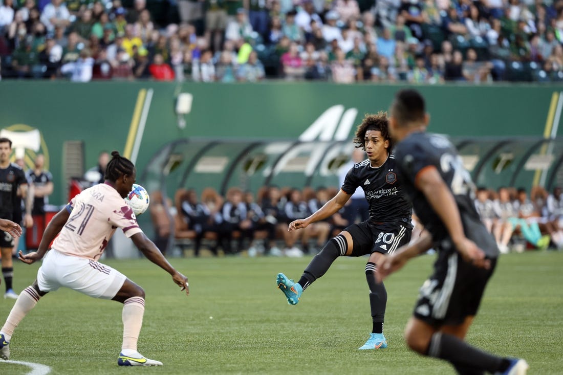 Jun 29, 2022; Portland, Oregon, USA; Houston Dynamo midfielder Adalberto Carrasquilla (20) takes a shot on goal against Portland Timbers midfielder Diego Chara (21) during the first half at Providence Park. Mandatory Credit: Soobum Im-USA TODAY Sports