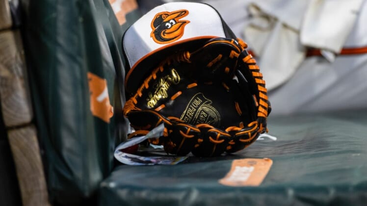 Jun 1, 2021; Baltimore, Maryland, USA; A Baltimore Orioles hat and glove are seen in the dugout during the fourth inning of the game between the Baltimore Orioles and the Minnesota Twins at Oriole Park at Camden Yards. Mandatory Credit: Scott Taetsch-USA TODAY Sports