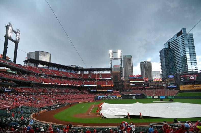 Jun 27, 2021; St. Louis, Missouri, USA;  St. Louis Cardinals grounds crew places the tarp on the field during a rain delay in the sixth inning against the Pittsburgh Pirates at Busch Stadium. Mandatory Credit: Jeff Curry-USA TODAY Sports