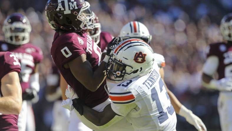 Nov 6, 2021; College Station, Texas, USA; Texas A&M Aggies wide receiver Ainias Smith (0) calls for a fair catch then is tackled by Auburn Tigers safety Ladarius Tennison (13) in the second quarter at Kyle Field. The Tigers were called for a penalty on the play. Mandatory Credit: Thomas Shea-USA TODAY Sports