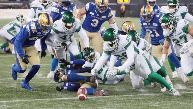 Dec 5, 2021; Winnipeg, Manitoba, CAN; Saskatchewan Roughriders wide receiver Mitchell Picton (81) fumbles the ball as Saskatchewan Roughriders running back Jamal Morrow (25) recovers it during the Canadian football League Western Conference Final game against the Winnipeg Blue Bombers at IG Field. Mandatory Credit: Bruce Fedyck-USA TODAY Sports