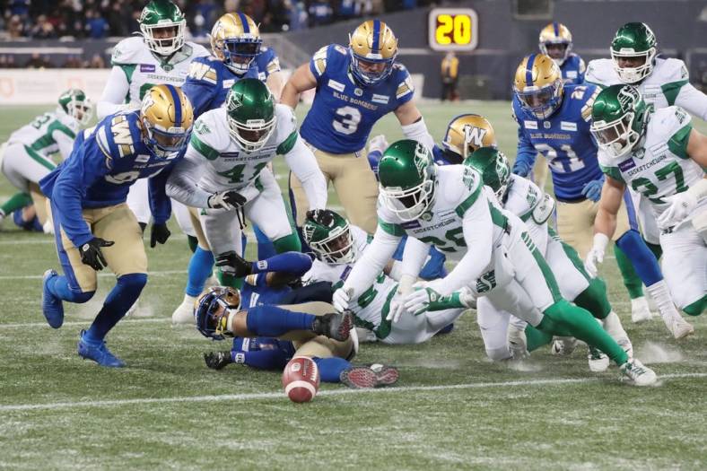 Dec 5, 2021; Winnipeg, Manitoba, CAN; Saskatchewan Roughriders wide receiver Mitchell Picton (81) fumbles the ball as Saskatchewan Roughriders running back Jamal Morrow (25) recovers it during the Canadian football League Western Conference Final game against the Winnipeg Blue Bombers at IG Field. Mandatory Credit: Bruce Fedyck-USA TODAY Sports