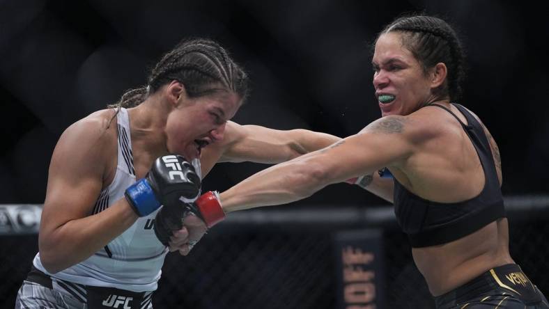 Dec 11, 2021; Las Vegas, Nevada, USA; Amanda Nunes moves in with a hit against Julianna Pena during UFC 269 at T-Mobile Arena. Mandatory Credit: Stephen R. Sylvanie-USA TODAY Sports