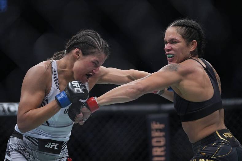 Dec 11, 2021; Las Vegas, Nevada, USA; Amanda Nunes moves in with a hit against Julianna Pena during UFC 269 at T-Mobile Arena. Mandatory Credit: Stephen R. Sylvanie-USA TODAY Sports