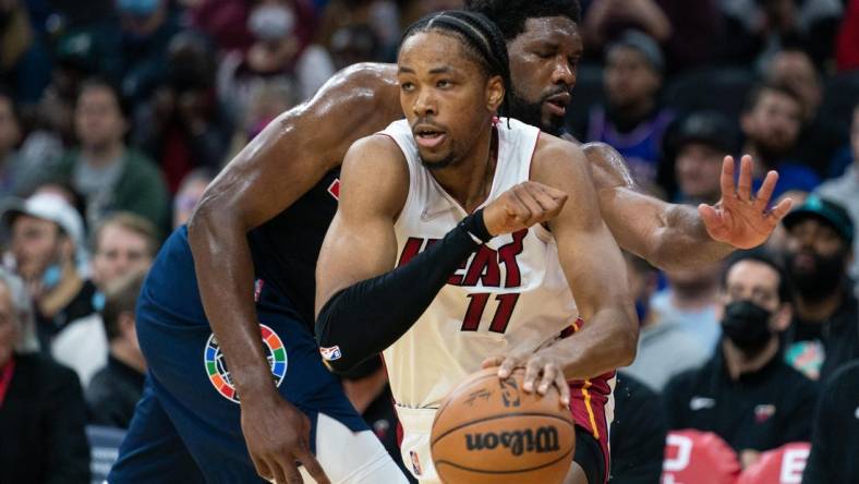 Dec 15, 2021; Philadelphia, Pennsylvania, USA; Miami Heat forward KZ Okpala (11) dribbles past Philadelphia 76ers center Joel Embiid (21) during the second quarter at Wells Fargo Center. Mandatory Credit: Bill Streicher-USA TODAY Sports