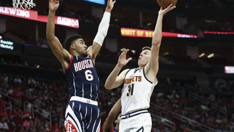 Jan 1, 2022; Houston, Texas, USA; Denver Nuggets forward Vlatko Cancar (31) shoots the ball as Houston Rockets forward Kenyon Martin Jr. (6) defends during the third quarter at Toyota Center. Mandatory Credit: Troy Taormina-USA TODAY Sports