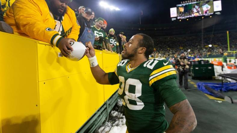 Green Bay Packers running back AJ Dillon (28) autographs a football after their game Sunday, December 12, 2021 at Lambeau Field in Green Bay, Wis. The Green Bay Packers beat the Chicago Bears 45-30.

Packers13 28