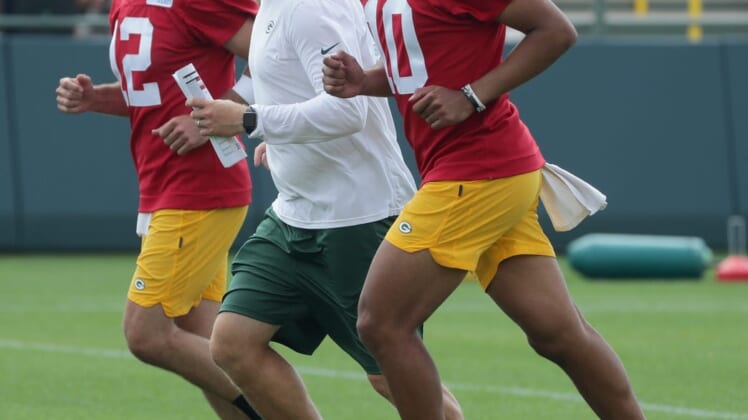 Green Bay Packers quarterbacks coach Luke Getsy runs between quarterback Aaron Rodgers (12) and quarterback Jordan Love (10) during the second day of training camp Thursday, July 29, 2021 in Green Bay, Wis.Mjs Packers30 29 Jpg Packers30