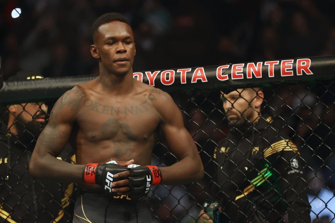 Feb 12, 2022; Houston, Texas, UNITED STATES; Israel Adesanya (red gloves) before the fight against Robert Whittaker (blue gloves) during UFC 271 at Toyota Center. Mandatory Credit: Troy Taormina-USA TODAY Sports