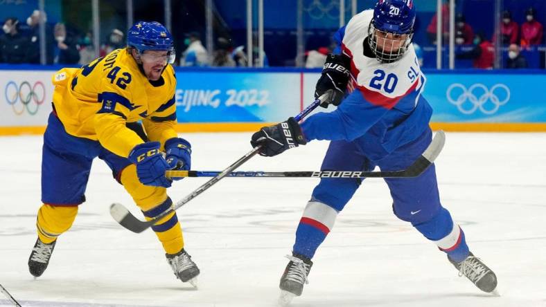 Feb 19, 2022; Beijing, China; Team Slovakia forward Juraj Slafkovsky (20) shoots the puck against Team Sweden forward Joakim Nordstrom (42) during the first period in the bronze medal men s ice hockey game during the Beijing 2022 Olympic Winter Games at National Indoor Stadium. Mandatory Credit: George Walker IV-USA TODAY Sports